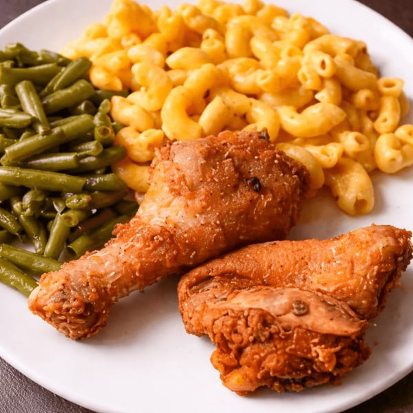 Dan's Soul Food fried chicken, macaroni and cheese, and green beans on a white plate.